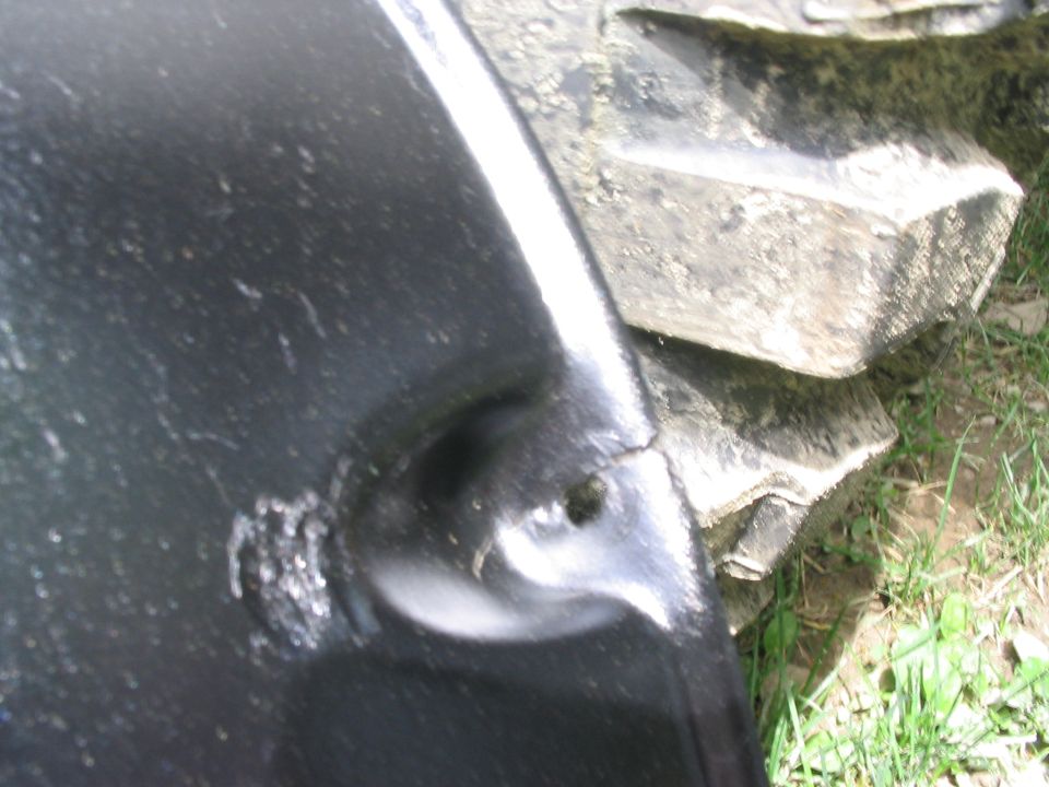 Black fender with a crack near a large, knobby tire