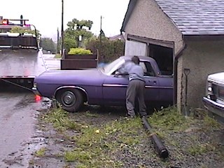 1968 Ford Ranchero - A purple 1968 Ford Ranchero is being backed into a garage, with a trailer attached to its front.