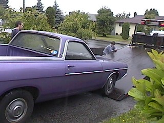 1968 Ford Ranchero - A purple 1968 Ford Ranchero is loaded onto a tow truck, possibly for repairs or transport.