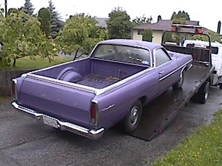 1968 Ford Ranchero - A purple 1968 Ford Ranchero pickup truck is loaded onto a flatbed tow truck.