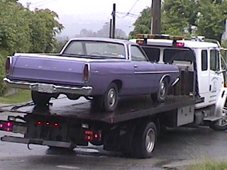 1968 Ford Ranchero - A purple 1968 Ford Ranchero is loaded onto a tow truck for transport.