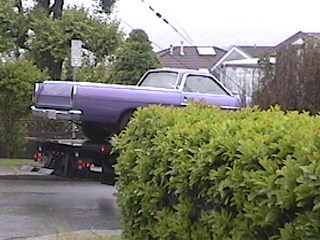 1968 Ford Ranchero - A purple 1968 Ford Ranchero is being towed on a flatbed truck.