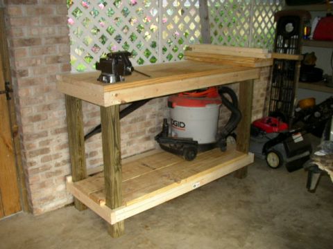 1995 Ford Bronco - A workbench holds a vise and shop vac, with a lawn mower visible in the background.