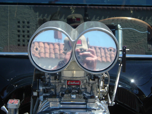Polished bugcatcher scoop over twin Edelbrock carbs on a blown black hot rod engine