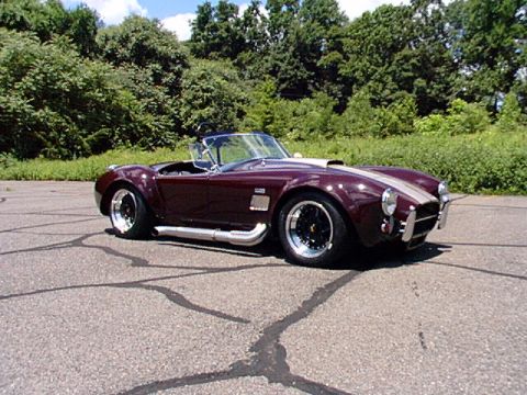 1967 Ford 427 - This AC Cobra replica features a prominent hood scoop and side exhaust pipes.