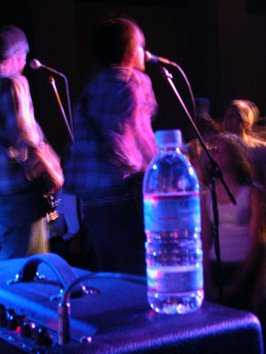 2000 Jeep Liberty - A water bottle sits on stage equipment during a live band performance.