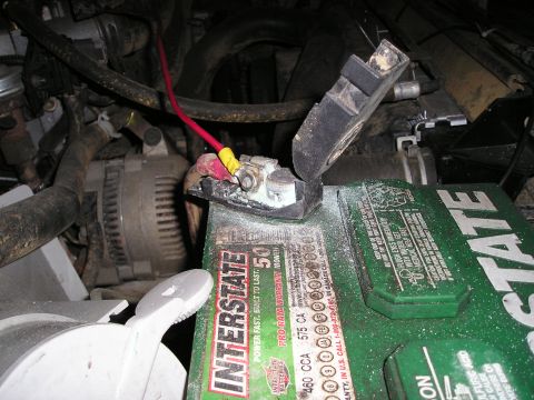 1996 Ford Bronco - Close-up view of an Interstate battery and its terminals, with the alternator visible in the background.