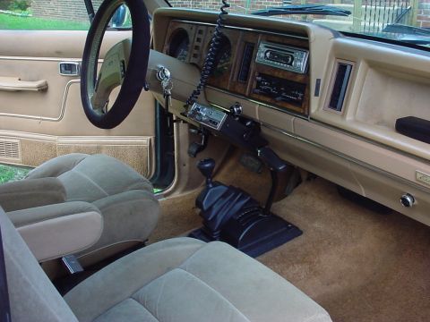 1985 Ford Bronco II - The interior of a 1985 Ford Bronco II features tan upholstery, wood-grain trim, and a prominent floor-mounted shifter.