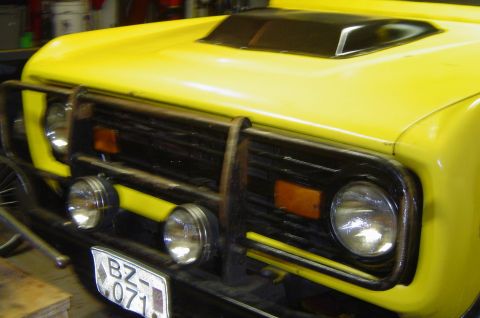 1974 Ford Bronco - Front view of a yellow SUV, possibly an International Harvester Scout, with a heavy-duty brush guard and auxiliary lights.