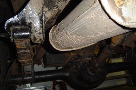 1974 Ford Bronco - Underside view shows the exhaust system and rear axle components of a vehicle.