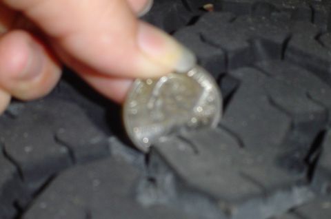1974 Ford Bronco - A dime is inserted into the tire tread to demonstrate tread depth.