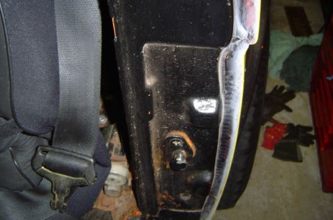 1974 Ford Bronco - Detail of the interior door jamb and seatbelt mechanism on a vehicle.