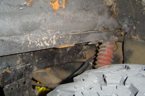 1974 Ford Bronco - Close-up view of a vehicle's undercarriage, revealing wear and tear on the suspension components.