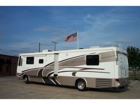 1989 Ford C-350 (Centurion Conversions) - Motorhome parked outdoors under a blue sky with clouds.