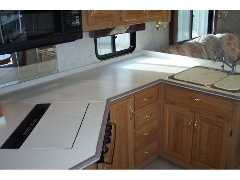 1989 Ford C-350 (Centurion Conversions) - Interior view of an RV kitchen, showing the counter, sink, and cabinetry.