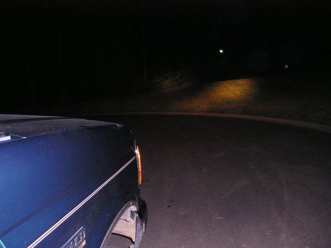 1996 Ford Bronco - A dark blue SUV is seen from the front quarter angle at night on a road.