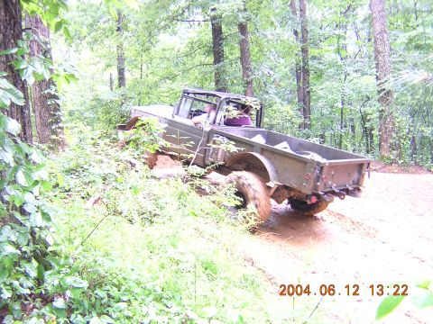 1984 Chevrolet Blazer - Off-road truck navigating a muddy path in a forest setting.