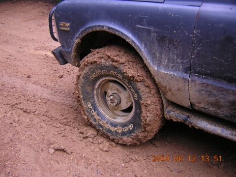 1984 Chevrolet Blazer - Vehicle tire covered in mud after driving off-road.