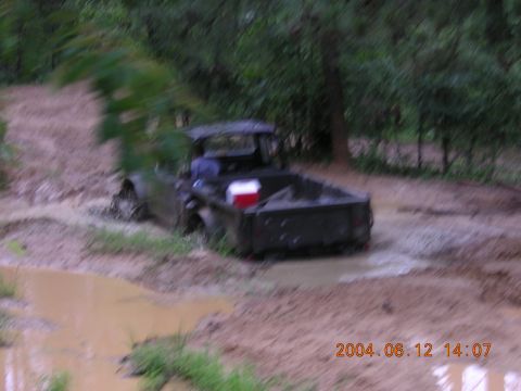 1984 Chevrolet Blazer - Pickup truck stuck in mud, with a cooler visible in the truck bed.