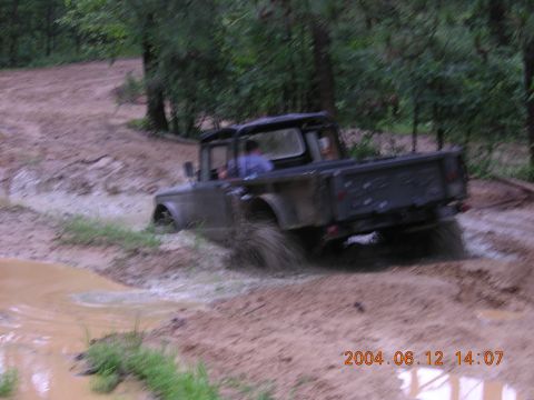 1984 Chevrolet Blazer - This truck is navigating a muddy trail with trees in the background.