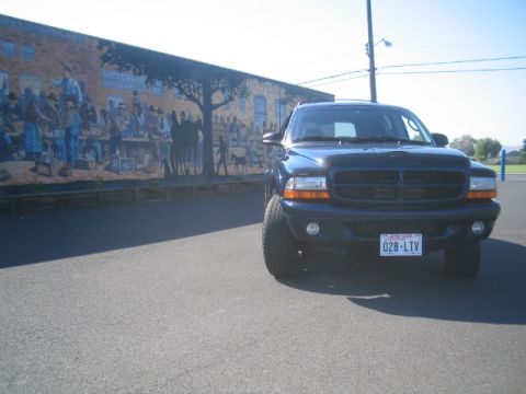 2001 Dodge Durango - A dark blue 2001 Dodge Durango is parked in front of a colorful mural on a brick building.