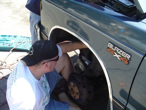 1993 Ford Bronco - A person is working on the brake assembly of a Chevrolet Blazer 4x4.