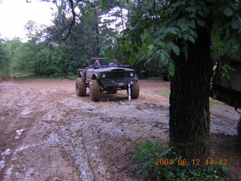 1984 Chevrolet Blazer - A dark-colored off-road vehicle navigates a muddy terrain, with another vehicle partially visible in the background and a date stamp in the…