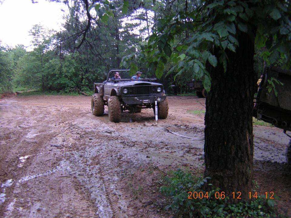 Dark off-road vehicle with large tires in mud. Date stamp visible