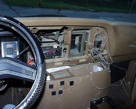 1988 Ford E250 - The interior of a van shows a disassembled dashboard with exposed wiring and an empty radio space.