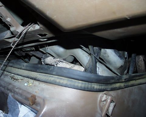 1988 Ford E250 - A close-up view of the underside of a vehicle's interior, revealing exposed components and wiring.
