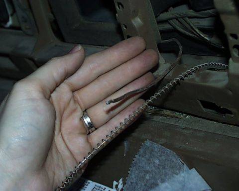1988 Ford E250 - Damaged coiled wire with exposed copper strands is held by a hand.