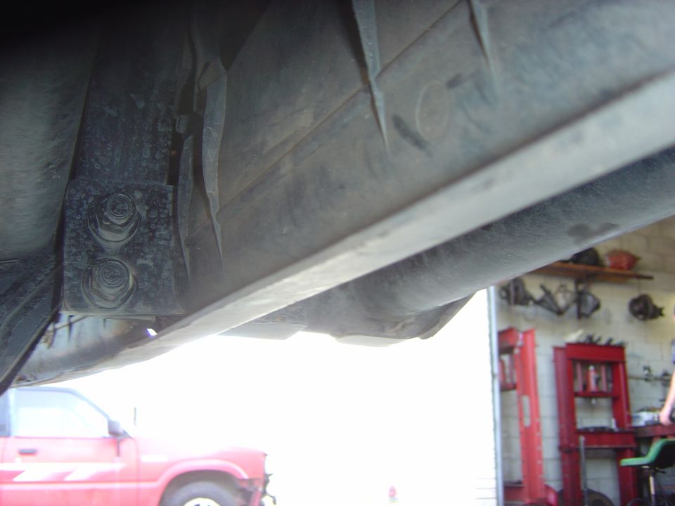 Underside of a red 1993 Ford Bronco showing frame and suspension components