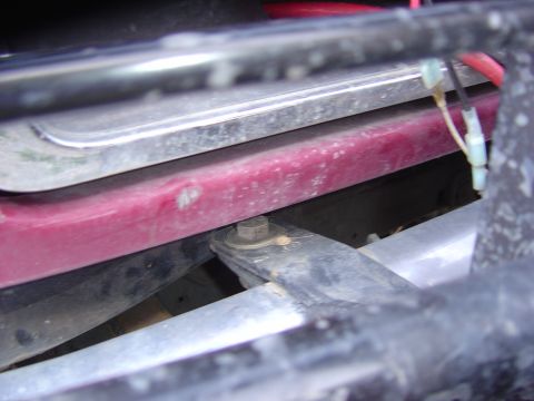 1993 Ford Bronco - Undercarriage view of a vehicle, focusing on a red component and suspension parts.