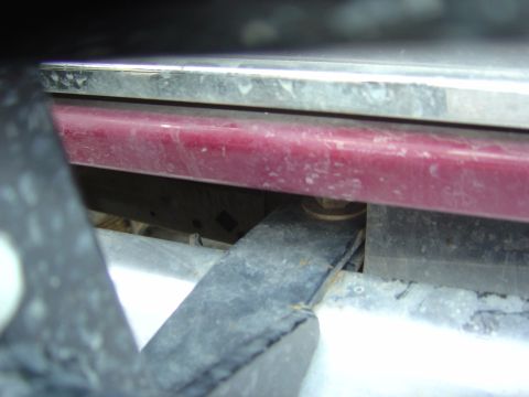1993 Ford Bronco - A close-up view of the underside of a vehicle, showing a red panel and metal components.