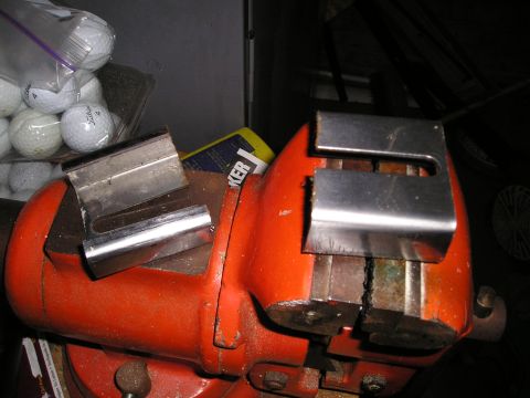 1996 Ford Bronco - Metal components are secured in a vise, with golf balls visible in the background.