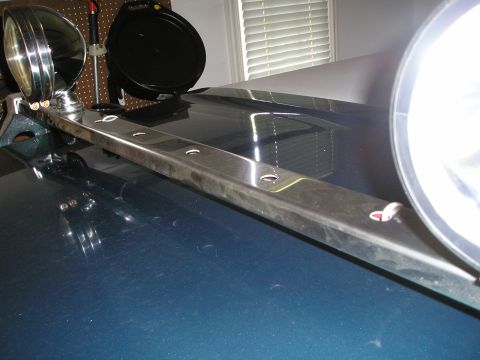1996 Ford Bronco - A close-up view of a light bar with two spotlights installed on the hood of a dark blue vehicle.