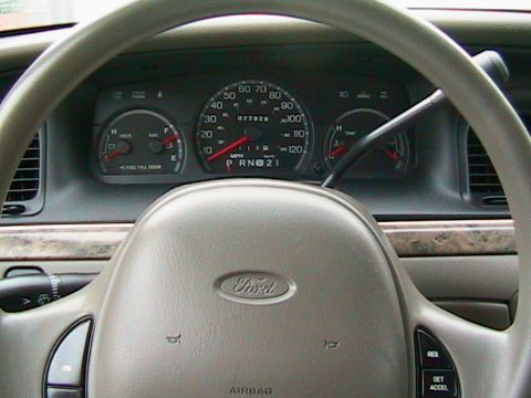 2000 Ford Crown Victoria - Close-up of the interior of a 2000 Ford Crown Victoria, focusing on the instrument cluster and steering wheel.