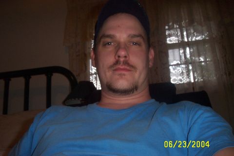 1979 Ford F-150 - Man with goatee and mustache wearing a blue t-shirt and dark baseball cap indoors, with a date stamp of 06/23/2004.