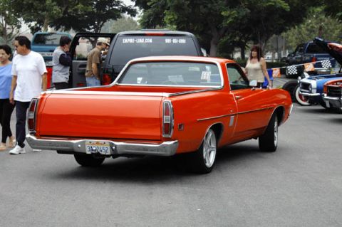 1970 Ford Ranchero - Rear view of an orange 1970 Ford Ranchero at a car show. Other vehicles and people are visible.