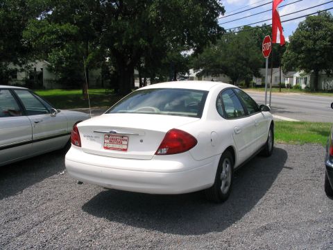 2000 Honda Accord - A white sedan is parked on a gravel lot next to another vehicle, with a stop sign and red flag visible.