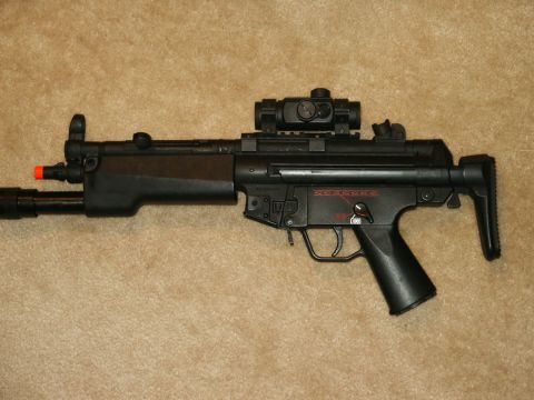 1991 Ford Bronco - A black submachine gun with an attached red dot sight is displayed against a neutral background.