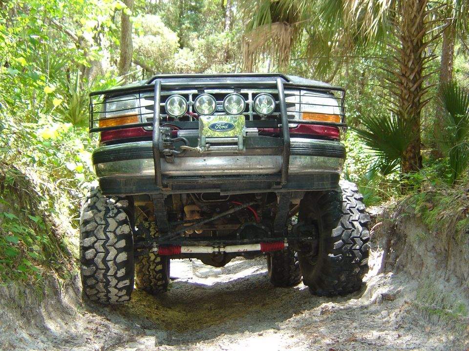 Lifted Ford 4x4 front view with brush guard, four driving lights, winch and solid front axle