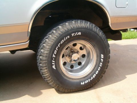 1996 Ford Bronco - Close-up of a BFGoodrich All-Terrain T/A tire mounted on a light-colored SUV a two-tone paint scheme.