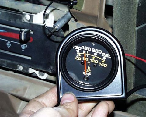 1988 Ford E250 - Close-up of an aftermarket temperature gauge showing readings in Fahrenheit and Celsius.