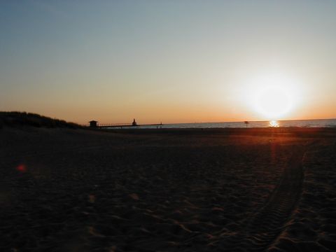 1997 Ford Taurus - A beach scene at sunset with a pier and lighthouse in the distance.