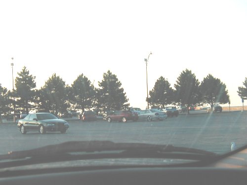 Dark sedan parked in a lot, seen from inside a vehicle