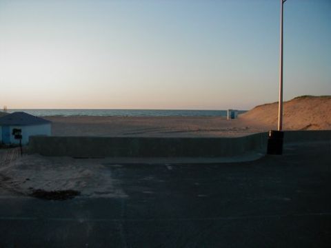 1997 Ford Taurus - A view of the beach and ocean at sunset, with a small building and sand dunes visible.