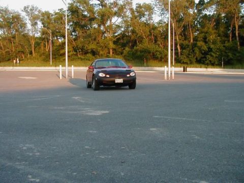 1997 Ford Taurus - A 1997 Ford Taurus is parked in an asphalt lot with trees in the background.