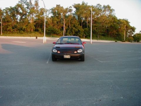 1997 Ford Taurus - Front view of a 1997 Ford Taurus parked in an empty lot during the day.