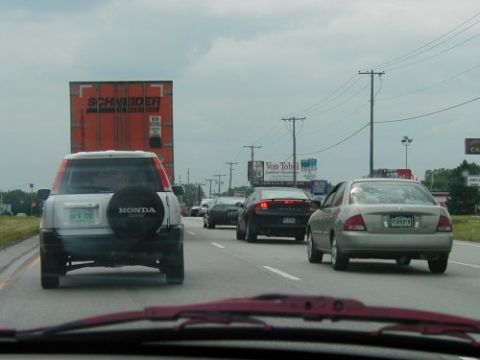 1997 Ford Taurus - Multiple vehicles are seen on a highway under an overcast sky.